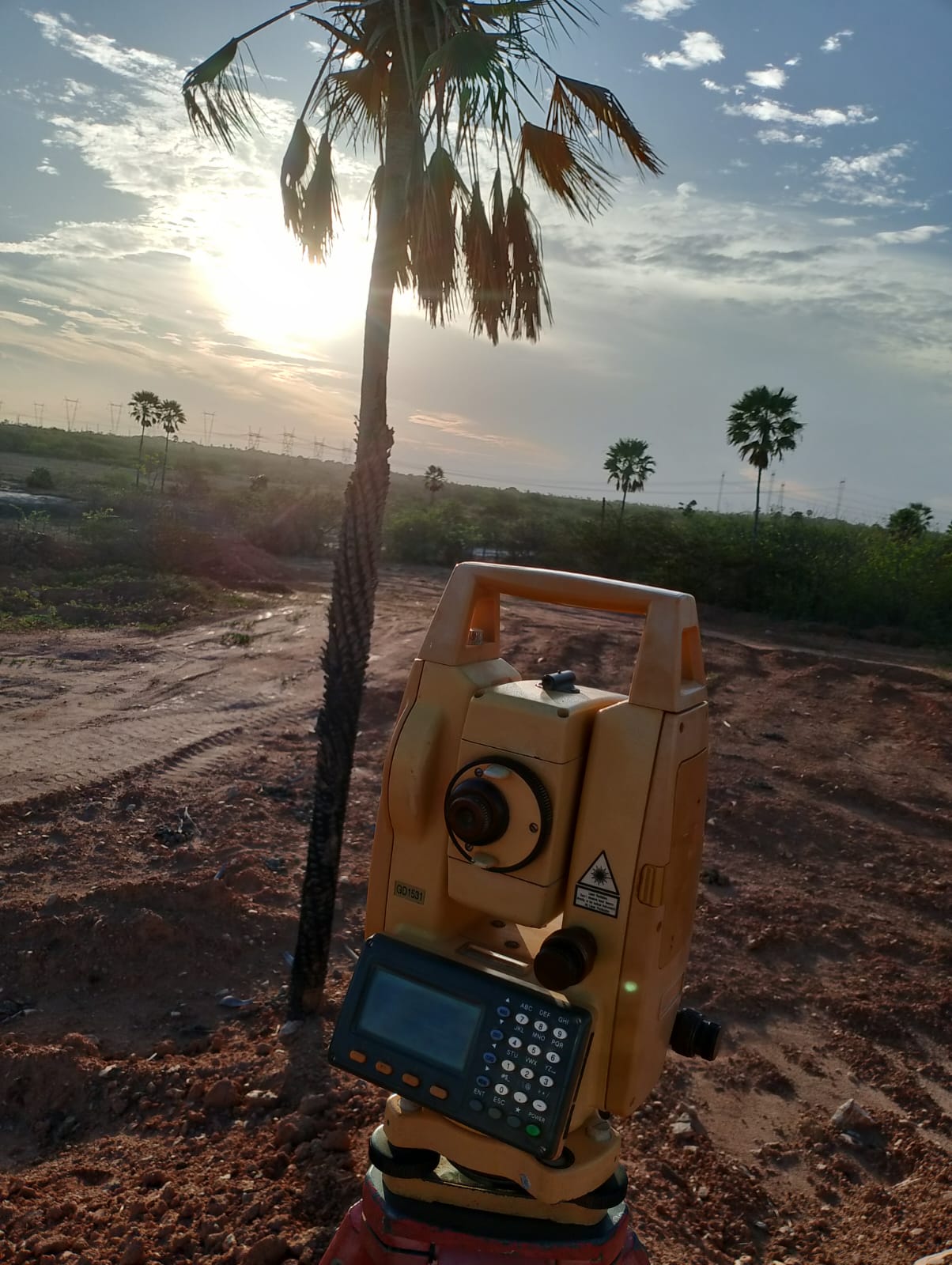 Equipamento de topografia em uso em terreno de obra de construção civil